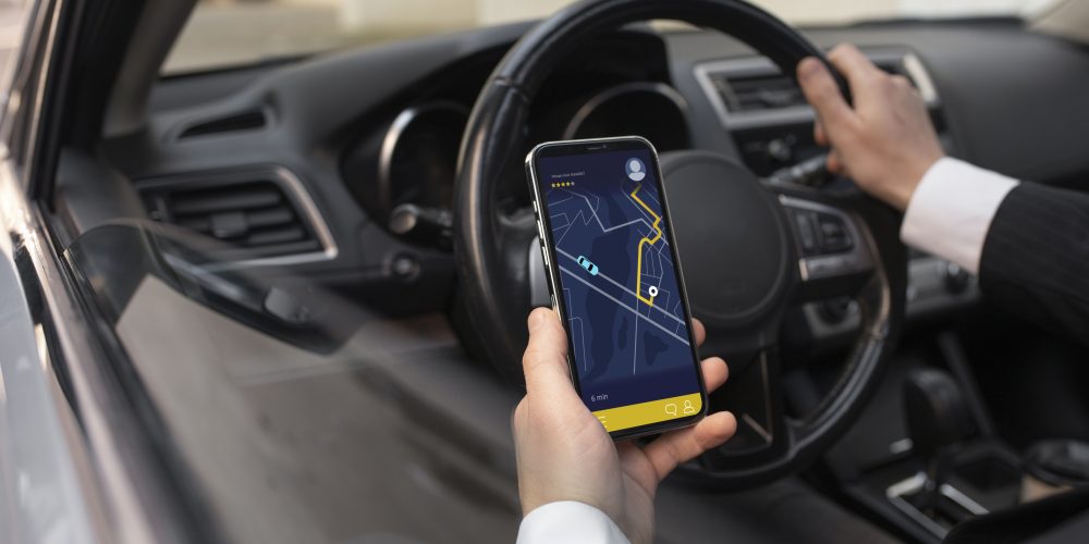 Direksiyon başında navigasyon uygulamasını kullanan sürücü – Denizli Taksibul sürücü hizmeti ve akıllı rota takibi.