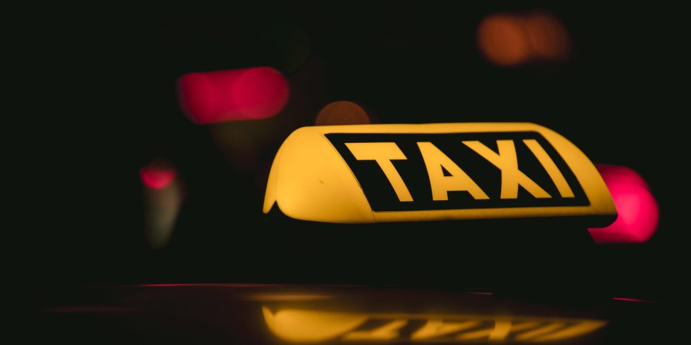 Gece karanlığında parlayan sarı taksi tabelası – Denizli Taksibul gece ulaşım hizmeti.